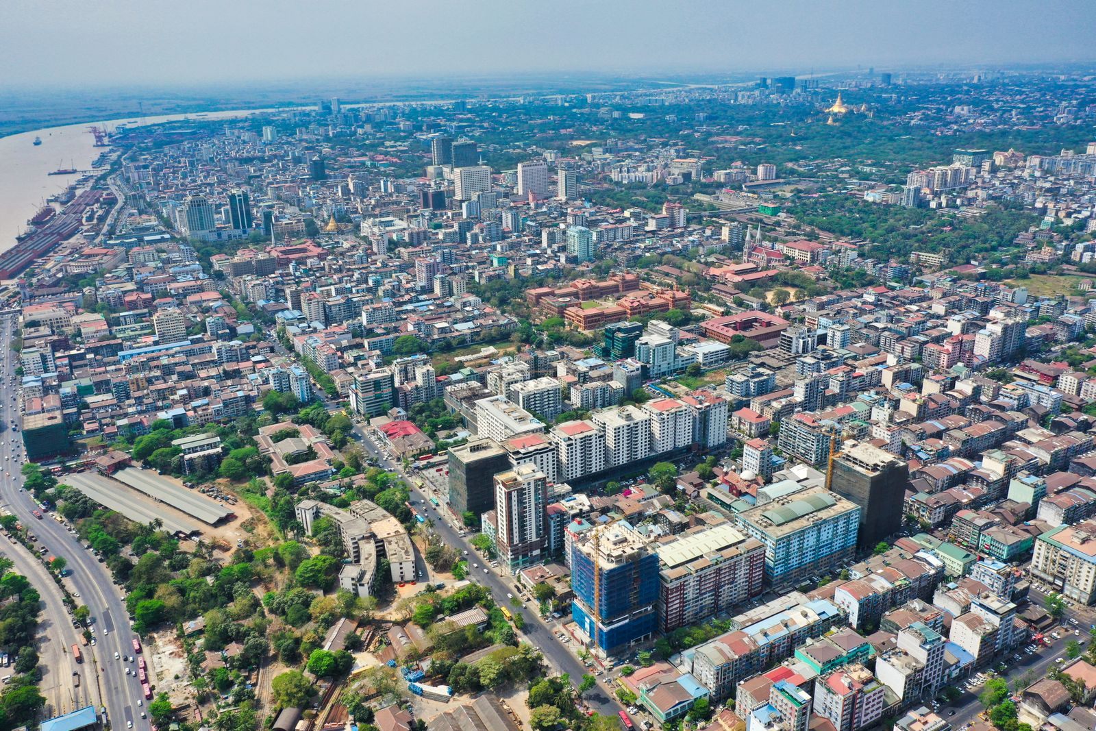 Aerial view of central Yangon with streets, apartment blocks and golden pagodas