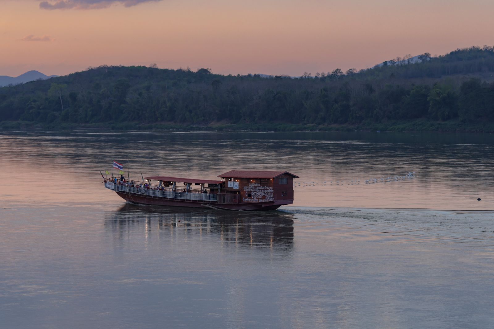 Boat on the Mekong River at sunset near Chiang Khan, an alternative to a Myanmar river cruise